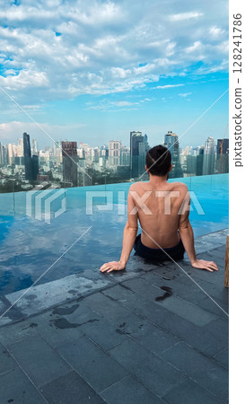 Experience a Serene Moment by the Infinity Pool Overlooking a Beautiful City Skyline Experience a Serene Moment by the Infinity Pool Overlooking a Beautiful City Skyline 128241786