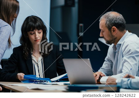 Executive business meeting with performance review on TV screen in luxury office boardroom 128242622