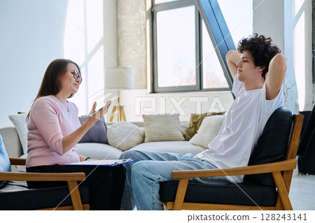 Young male patient talking to professional psychologist social worker counselor Young male patient talking to professional psychologist social worker counselor 128243141