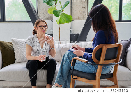Mental therapy session, middle aged woman patient talking to professional psychologist Mental therapy session, middle aged woman patient talking to professional psychologist 128243160