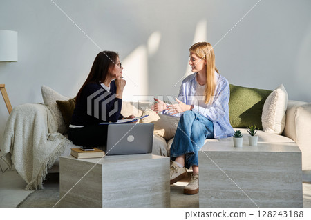 Young smiling girl patient in therapy session with social mental therapist Young smiling girl patient in therapy session with social mental therapist 128243188