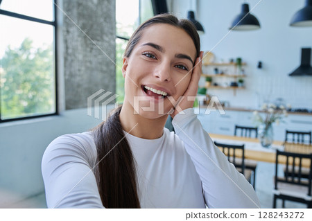 Close-up selfie portrait of teenage female looking at web camera 128243272