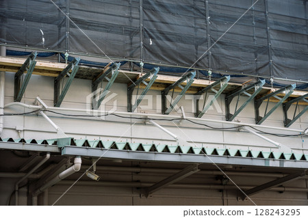 Scaffolding brackets installed on the wall of a building Scaffolding brackets installed on the wall of a building 128243295