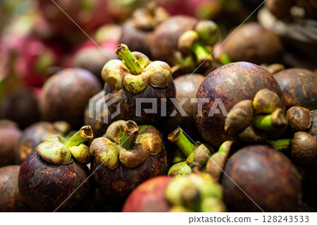 Fresh juicy mangosteens fruits arranged in neat rows at local southeast asian market, full frame 128243533