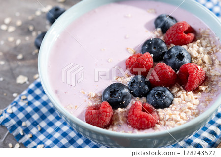 Healthy smoothie bowl with berries on wooden table. 128243572