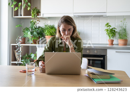 Anxious woman overwork on laptop, concentrating on elearning study with books, papers at home 128243623