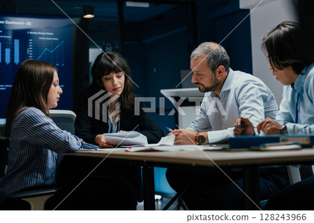 Business executives and assistants brainstorming investment risk evaluation in corporate boardroom 128243966