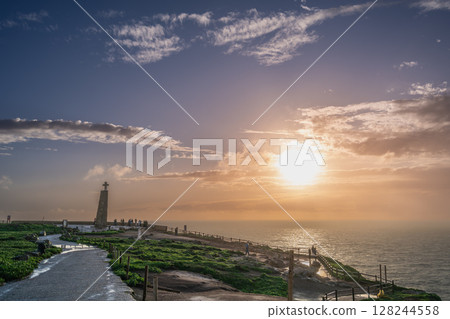 Sunset at Cabo de Roca with Iconic Cross Overlooking Ocean Horizon. 128244558