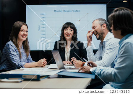 Fun and a laugh at a business meeting in luxury office boardroom Fun and a laugh at a business meeting in luxury office boardroom 128245115