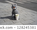 This charming and adorable plush wolf is sitting comfortably with a delightful coffee cup 128245381