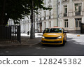 A bright yellow taxi cab is making a turn at a busy urban intersection in the city 128245382