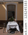 A Charming Outdoor Dining Setup Featuring an Elegant Table and Inviting Ambiance 128245383