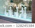 An Elegant Flower Display showcased beautifully in the window of a Modern Shop setting 128245384