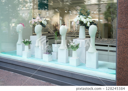 An Elegant Flower Display showcased beautifully in the window of a Modern Shop setting An Elegant Flower Display showcased beautifully in the window of a Modern Shop setting 128245384