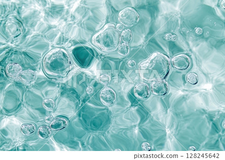 Close-up of abstract turquoise bubbles in liquid. Soft glow, smooth shapes, delicate texture. Macro shot with vibrant light. Fresh, pure, clean concept. Background, chemistry, skincare. Banner 128245642