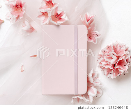 Blank vertical paper card near pink azalea flowers and ribbons top view, spring wedding mockup Blank vertical paper card near pink azalea flowers and ribbons top view, spring wedding mockup 128246648