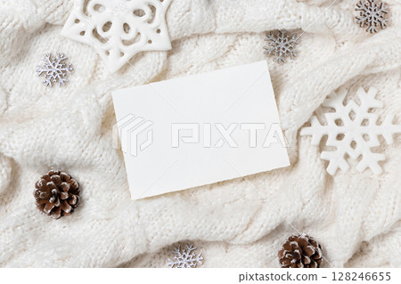 Horizontal blank card on white knitted sweater near Christmas decor, winter Holiday mockup 128246655