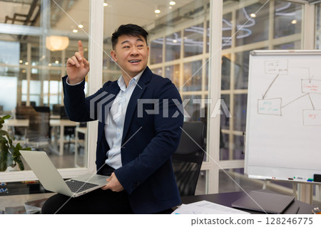 Young asian businessman working on a laptop in his office Young asian businessman working on a laptop in his office 128246775