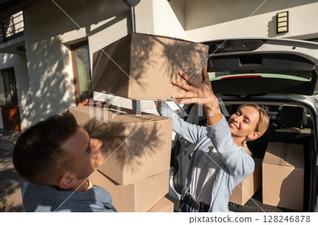 Young couple looking involved while preparing boxes for moving to a new house 128246878