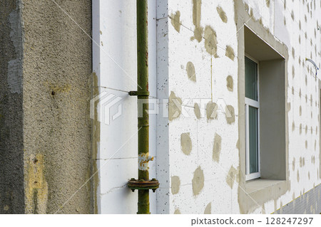 Thermal insulation of the facade of a residential building with thermal insulation material plates 128247297