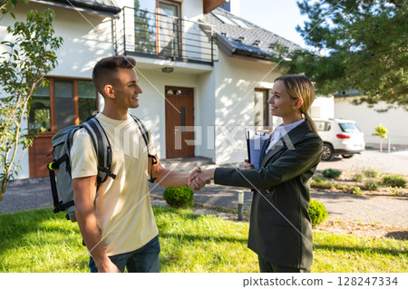 Real estate agent shaking hands with a new client and both looking contented 128247334