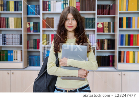Portrait of teenage beautiful girl high school student posing in library classroom 128247477