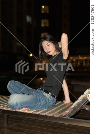 Portrait of beautiful Asian woman at night at pool during holiday Portrait of beautiful Asian woman at night at pool during holiday 128247601