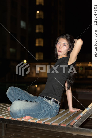 Portrait of beautiful Asian woman at night at pool during holiday Portrait of beautiful Asian woman at night at pool during holiday 128247602