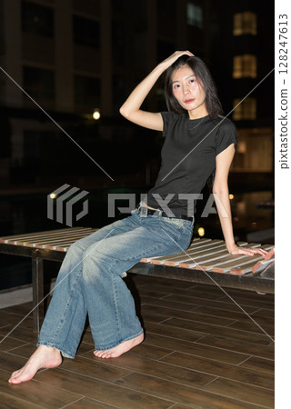 Portrait of beautiful Asian woman at night at pool during holiday Portrait of beautiful Asian woman at night at pool during holiday 128247613