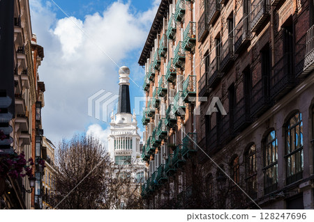 Charming architecture and blue skies define a picturesque street scene in Madrid, Spain. 128247696