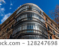 Majestic architecture featuring intricate ironwork and glass in Madrid against a brilliant blue sky. 128247698