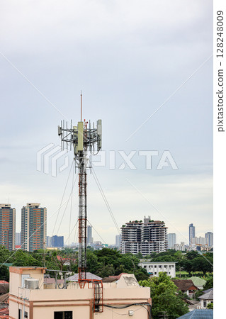 Wireless Communication Antenna pole, Mobile phone mast antenna pole on top of dilapidated building 128248009