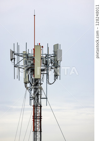 Wireless Communication Antenna pole, Mobile phone mast antenna pole on top of dilapidated building 128248011
