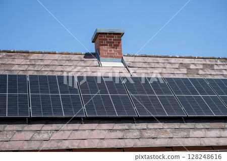 Solar panels installed on tiled roof of residential house in sunny weather Solar panels installed on tiled roof of residential house in sunny weather 128248616