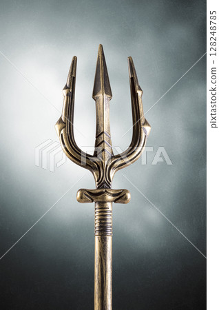 Golden trident over dark misty background 128248785