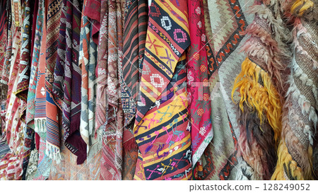 Traditional Turkish carpets and rugs hanging on bazaar market in Cappadocia 128249052