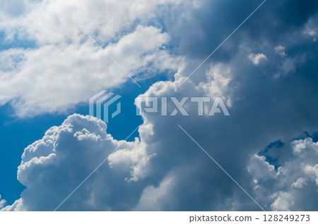Thick clouds shining through in sunlight against a blue sky. Movement of substances in the lower atmosphere 128249273