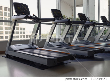 Side view of Two treadmill machines in fitness center. Side view of Two treadmill machines in fitness center. 128249342