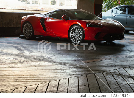 Ferrari red sports car parked in the parking lot. 128249344
