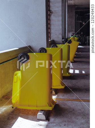 View of After cleaning big plastic yellow garbage container and turn upside down to dry. 128249433