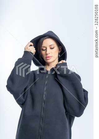 Portrait beautiful woman of model appearance. Girl in black sweatshirt on grey background. Pretty female with trendy makeup posing in studio. Vertical photo. High quality photo Portrait beautiful woman of model appearance. Girl in black sweatshirt on grey background. Pretty female with trendy makeup posing in studio. Vertical photo. High quality photo 128250108