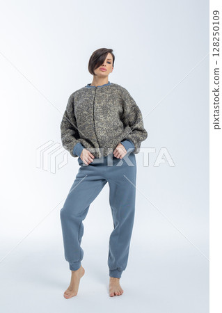 Portrait of young woman warm knitted jumper with zipper on light background. Studio photography. Vertical photo. High quality photo 128250109