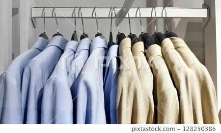 Jackets on hangers in a store on a neutral background 128250386