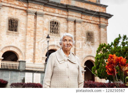 Senior woman at the beautiful colonial town of Concepcion located in the department of Antioquia in Colombia. Church of Our Lady of the Immaculate Conception. 128250567