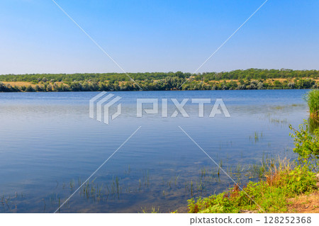 Summer landscape with beautiful river, green trees and blue sky 128252368