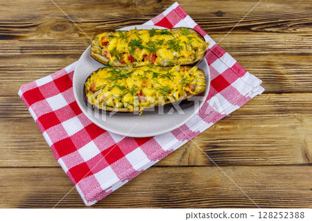 Baked stuffed eggplants on a wooden table. Healthy food and dieting concept Baked stuffed eggplants on a wooden table. Healthy food and dieting concept 128252388