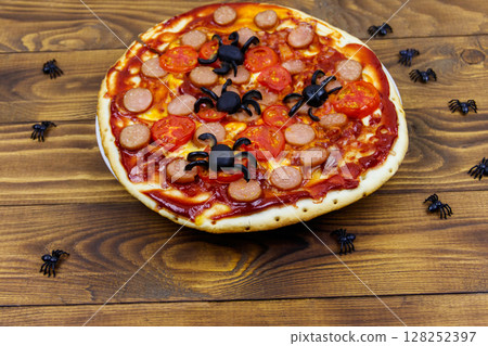 Halloween pizza with spiders on wooden table Halloween pizza with spiders on wooden table 128252397