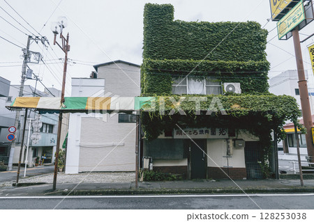 A retro store building with ivy-covered exterior walls 128253038