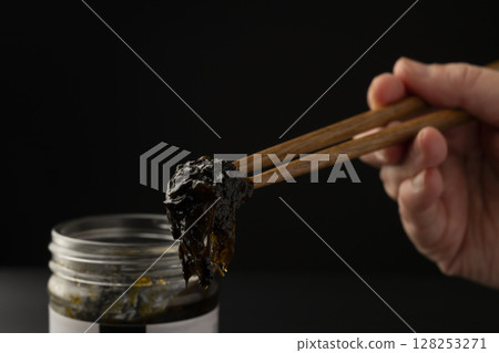Lifting the seaweed tsukudani from the jar with chopsticks Lifting the seaweed tsukudani from the jar with chopsticks 128253271