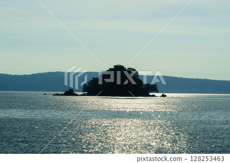 The sea illuminated by the sunset 128253463